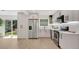 Bright kitchen with stainless appliances, sleek white cabinets, and a sliding door to the backyard at 118 Deacon Jones Blvd, Orlando, FL 32810