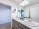 Bathroom featuring double sinks, gray cabinetry, and decorative mirror at 1181 Lone Palm Way, St Cloud, FL 34771