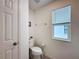 Powder room featuring a white toilet and a window offering natural light, creating a functional space at 1181 Lone Palm Way, St Cloud, FL 34771