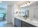 Bright bathroom featuring double sinks, gray cabinetry, and neutral decor at 1181 Lone Palm Way, St Cloud, FL 34771