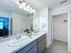 A bright bathroom with double sinks, a large mirror, and modern finishes at 1181 Lone Palm Way, St Cloud, FL 34771