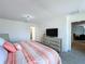 Bright bedroom featuring a striped bedspread, television, and neutral gray carpet flooring at 1181 Lone Palm Way, St Cloud, FL 34771