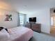 A cozy bedroom with a stylish bed, framed artwork, and neutral walls at 1181 Lone Palm Way, St Cloud, FL 34771