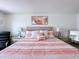 Stylish bedroom features a striped bedspread, floral artwork, lamps and a comfortable chair at 1181 Lone Palm Way, St Cloud, FL 34771