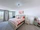 Comfortable bedroom features a striped bedspread, chair and artwork at 1181 Lone Palm Way, St Cloud, FL 34771
