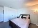 A cozy bedroom with neutral-toned walls, closet, and dark furnishings with a comfortable bed at 1181 Lone Palm Way, St Cloud, FL 34771