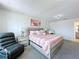 A stylish bedroom featuring a bed, bedside table, and a comfortable chair, exuding relaxation at 1181 Lone Palm Way, St Cloud, FL 34771