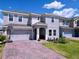 Two-story home with a brick paver driveway, landscaping and a two-car garage at 1181 Lone Palm Way, St Cloud, FL 34771