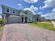 Two-story home with a brick paver driveway, landscaping and a two-car garage at 1181 Lone Palm Way, St Cloud, FL 34771