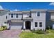 Two-story home with a brick paver driveway, landscaping and a two-car garage at 1181 Lone Palm Way, St Cloud, FL 34771