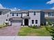 Two-story home with a brick paver driveway, landscaping and a two-car garage at 1181 Lone Palm Way, St Cloud, FL 34771