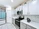 Well-maintained kitchen featuring stainless steel appliances, gray cabinetry, and quartz countertops at 1181 Lone Palm Way, St Cloud, FL 34771