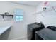 Laundry room with modern washer and dryer, shelving, and a window for natural light at 1181 Lone Palm Way, St Cloud, FL 34771