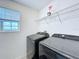 Modern laundry room with front-load washer and dryer and wire rack shelving at 1181 Lone Palm Way, St Cloud, FL 34771
