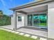 Covered patio with sliding glass doors, overlooking the landscaped backyard at 12313 Prairie Plantation Way, Orlando, FL 32824