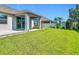 Spacious backyard features lush green grass, covered patio, and well-maintained landscaping, perfect for outdoor activities at 12313 Prairie Plantation Way, Orlando, FL 32824