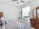 Comfortable bedroom with a ceiling fan, dark wood dresser, and view to the living room at 12313 Prairie Plantation Way, Orlando, FL 32824
