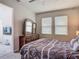 Bright bedroom with large windows features a dark wood dresser and an adjacent doorway at 12313 Prairie Plantation Way, Orlando, FL 32824