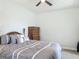 Bedroom with plush carpeting features a ceiling fan and a dark wood dresser with matching bedframe at 12313 Prairie Plantation Way, Orlando, FL 32824