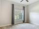 Cozy bedroom features a ceiling fan, large window with gray curtains offering a scenic view at 12313 Prairie Plantation Way, Orlando, FL 32824
