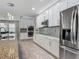 Modern kitchen featuring stainless steel appliances, white cabinetry, and a stylish backsplash at 12313 Prairie Plantation Way, Orlando, FL 32824