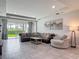 Spacious living room with a large sofa, tile floors, recessed lighting and art at 12313 Prairie Plantation Way, Orlando, FL 32824