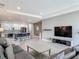 Spacious living room with a modern kitchen, sleek TV setup, and stylish gray color palette at 12313 Prairie Plantation Way, Orlando, FL 32824