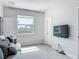 Bright living room with neutral color scheme, large window and mounted TV at 12313 Prairie Plantation Way, Orlando, FL 32824