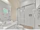 Bright bathroom with white cabinets, quartz counters and glass shower doors at 1428 Reunion Blvd, Kissimmee, FL 34747