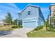 Charming two-story home with blue siding, a two-car garage, and manicured landscaping at 1428 Reunion Blvd, Kissimmee, FL 34747