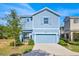 Charming two-story home with blue siding, a two-car garage, and manicured landscaping at 1428 Reunion Blvd, Kissimmee, FL 34747