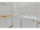 Bright laundry room featuring modern washer, dryer, ample storage, and wire shelving at 1428 Reunion Blvd, Kissimmee, FL 34747