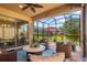 Relaxing screened lanai featuring comfortable seating, a ceiling fan, and a view of the landscaped backyard at 1631 Nina Dr, Davenport, FL 33837