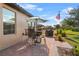Outdoor patio with seating, umbrella-covered table, grill, and nicely landscaped yard with an American flag at 1631 Nina Dr, Davenport, FL 33837