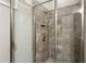 Bathroom shower with gray tile, a shower caddy and glass doors at 1631 Nina Dr, Davenport, FL 33837