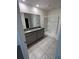 Bathroom with double vanity, granite countertop, tiled floor and glass-enclosed shower at 1828 Buckeye Rd, Davenport, FL 33837