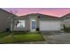Charming single-story home featuring a manicured lawn, attached garage, and inviting blue front door, perfect for first-time homebuyers at 1828 Buckeye Rd, Davenport, FL 33837