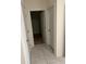 Hallway with multiple white doors, closet and neutral tile flooring at 1828 Buckeye Rd, Davenport, FL 33837