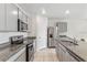Modern kitchen with stainless steel appliances, gray cabinets, granite counters, and a functional layout for easy meal preparation and cooking at 1828 Buckeye Rd, Davenport, FL 33837