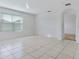 Spacious living room with tile flooring and a large window, creating a bright and welcoming space for relaxation and entertainment at 1828 Buckeye Rd, Davenport, FL 33837
