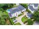 Stunning aerial view of a luxury home with a pool, lush landscaping, and a spacious driveway with multiple cars at 202 Acadia Ter, Kissimmee, FL 34747