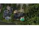Aerial view showcases a large house with a backyard pool, a lake nearby, and surrounded by lush greenery at 202 Acadia Ter, Kissimmee, FL 34747