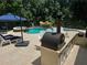 Beautiful backyard pool with waterfalls, a hot tub, outdoor kitchen, umbrella and lots of patio space at 202 Acadia Ter, Kissimmee, FL 34747