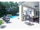 Back patio featuring seating areas and views of the pool and lush landscaping at 202 Acadia Ter, Kissimmee, FL 34747