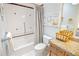 Charming bathroom featuring a shower-tub, decorative tile accents and beach themed artwork on the pale blue wall at 202 Acadia Ter, Kissimmee, FL 34747