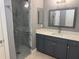 Bathroom featuring gray cabinets, quartz countertop, and a glass enclosed shower at 202 Acadia Ter, Kissimmee, FL 34747