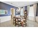 Elegant dining room with blue walls, a chandelier and a large wood table with chairs at 202 Acadia Ter, Kissimmee, FL 34747