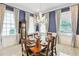 Elegant dining room with blue walls, a chandelier and a large wood table with eight chairs at 202 Acadia Ter, Kissimmee, FL 34747