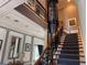 A grand two-story entrance foyer featuring an elevator and stairs with wrought iron railings at 202 Acadia Ter, Kissimmee, FL 34747