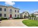 Stunning two-story home with a red front door, winding driveway, and manicured lawn and garden at 202 Acadia Ter, Kissimmee, FL 34747